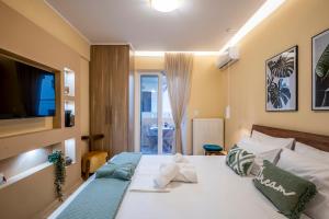 1 dormitorio con 1 cama y TV en la pared en Upper Samitos Rooms en Áyios Andónios