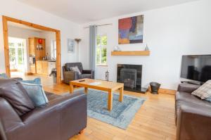 a living room with a couch and a table and a fireplace at Rathmullan Village Home in Rathmullan