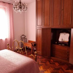 ラポラーノ・テルメにあるSan Francescoのベッドルーム1室(ベッド1台付)、キャビネット(テレビ付)