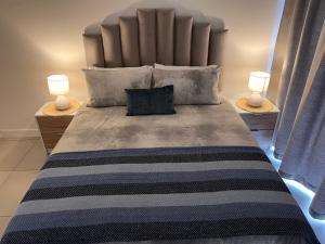 Un pat sau paturi într-o cameră la Ultra Modern Apartment - Self Catering