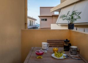 a table with a plate of fruit on a balcony at Upper Samitos Rooms in Áyios Andónios