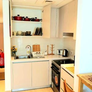 a kitchen with white cabinets and a sink and a stove at B8 Studio close to Formula 1 with Ferrari world view in Abu Dhabi