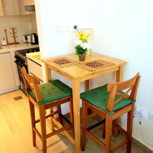 een keuken met een houten tafel en 2 stoelen bij B8 Studio close to Formula 1 with Ferrari world view in Abu Dhabi