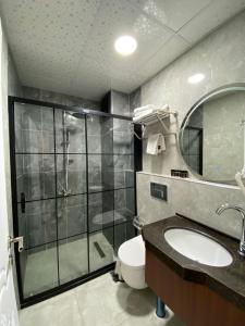 ein Bad mit einer Dusche, einem WC und einem Waschbecken in der Unterkunft Med Life Hotel İstanbul Airport in Arnavutköy