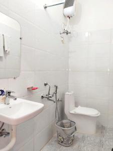 a bathroom with a sink and a toilet and a mirror at BAGH VILLA HOME STAY in Rājgarh