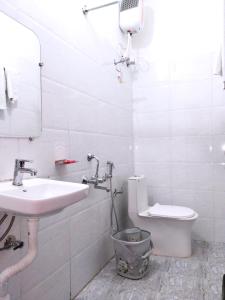 ein weißes Bad mit einem Waschbecken und einem WC in der Unterkunft BAGH VILLA HOME STAY in Rājgarh
