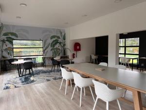 una stanza con un grande tavolo, sedie e tavoli di Ultra Modern Apartment - Self Catering a Ballito