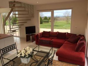 a living room with a red couch and a staircase at L'Atelier 4 stars Luxury, Hot Tub, Pool in Nambsheim