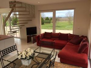 ein Wohnzimmer mit einem roten Sofa und einer Treppe in der Unterkunft L'Atelier 4 stars Luxury, Hot Tub, Pool in Nambsheim