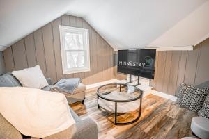 een woonkamer met een bank en een tv bij Contempo Cottage in Minneapolis