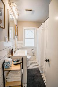 een badkamer met een wastafel, een toilet en een raam bij Contempo Cottage in Minneapolis