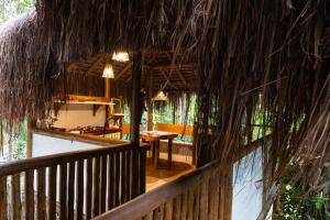 um alpendre de uma cabana com uma mesa e uma sala de jantar em Cabana na árvore na Bahia! Para viver uma experiência de hospedagem pertinho da praia em Maraú