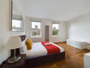 a bedroom with a bed with a lamp and windows at Luxury 4 Bedroom 2 Bathroom House Westminister Big Ben in London