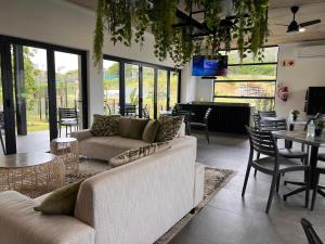 un soggiorno con divani, tavoli e sedie di Ultra Modern Apartment - Self Catering a Ballito