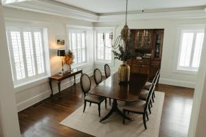 a dining room with a table and chairs and windows at Southmoreland at Oak Street Mansion in Kansas City