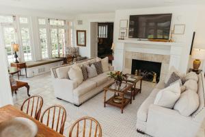 a living room with white furniture and a fireplace at Southmoreland at Oak Street Mansion in Kansas City