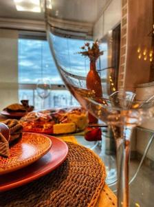 una mesa con platos de comida y una copa de vino en Banho de Lua - Vaca Brava, en Goiânia