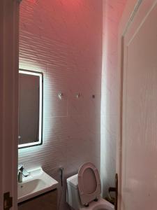 a pink bathroom with a toilet and a sink at شاليه الفخامه٢ in Ḑubā