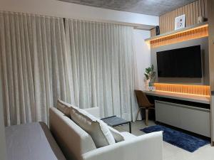 a living room with a couch and a flat screen tv at Vida Urbana - Connect - Setor Oeste in Goiânia