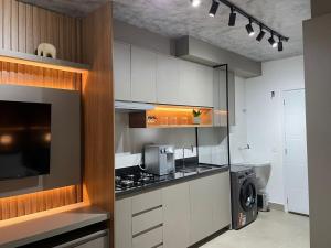 a kitchen with white cabinets and a stove top oven at Vida Urbana - Connect - Setor Oeste in Goiânia