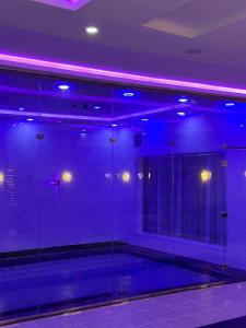 a room with purple lights and a tennis court at شاليه الفخامه٢ in Ḑubā