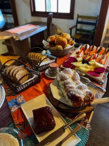 uma mesa com vários tipos diferentes de alimentos em Pousada Kokopelli em Lavras Novas