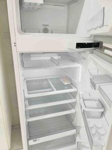 a white refrigerator with its door open with its door at Pérola do Aquarius in São José dos Campos