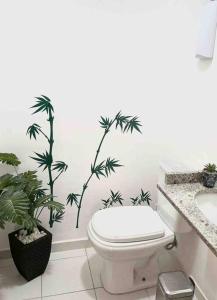 a bathroom with a toilet and plants on the wall at Pérola do Aquarius in São José dos Campos