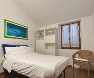 een slaapkamer met een bed, een stoel en een raam bij Appartamento Vecchia Farmacia 111 in Scarperia