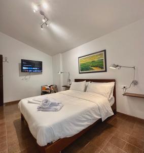 een slaapkamer met een bed met witte lakens en een televisie bij Appartamento Vecchia Farmacia 111 in Scarperia