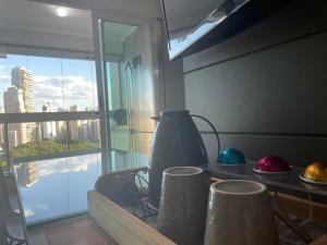 uma mesa com um vaso e bolas numa janela em Encantare - Easy Life - Vaca em Goiânia