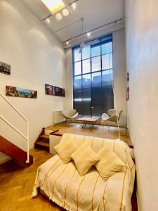 a bedroom with a bed and a large window at Tucuman 685 in Buenos Aires