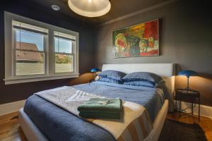 a bedroom with a large bed and two windows at Saint Paul Vacation Rental Near Downtown! in Saint Paul