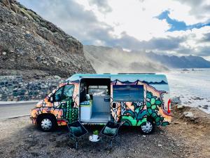 El GuinchoOn Road- feel freedom with campervan!的停在海滩边的带椅子的货车