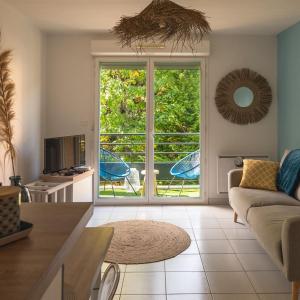 een woonkamer met een bank en een televisie bij Appartement cosy in Sarlat-la-Canéda
