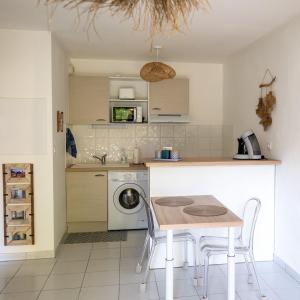 een keuken met een tafel en een wasmachine bij Appartement cosy in Sarlat-la-Canéda