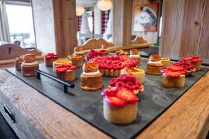 un montón de pastelitos sentados en una mesa en Hôtel Alpina & SPA, en Les Gets