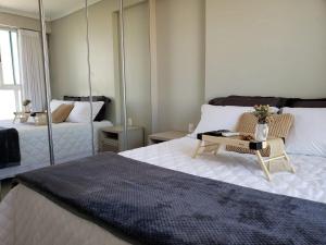 una camera con un grande letto e uno specchio di Nature - Easy Life - Vaca Brava a Goiânia