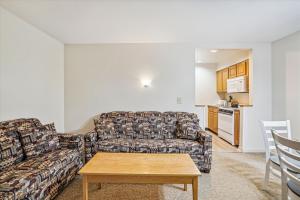 uma sala de estar com um sofá e uma mesa em Cedarbrook Queen Suite 108 em Killington