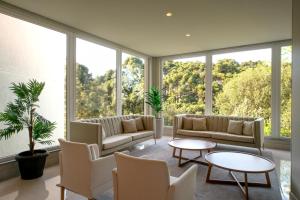 a living room with large windows and couches and tables at Laghetto Resort Golden Oficial in Gramado