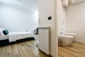 La salle de bains blanche est pourvue d'un lit et d'une baignoire. dans l'établissement Sea City In Bed, à Naples