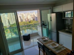 a kitchen with a table and a view of a city at 01 Qt.| 2 Hosp. | Linda Vista | Goiânia Shopping in Goiânia