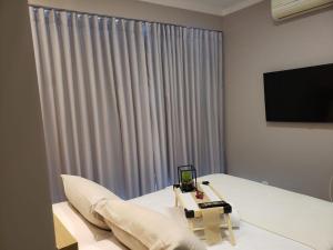 a room with a bed with a television and a couch at 01 Qt.| 2 Hosp. | Linda Vista | Goiânia Shopping in Goiânia
