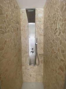 um chuveiro na casa de banho com uma parede de pedra em L’Attico Sul Fiume center home em Ascoli Piceno