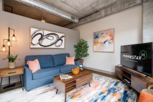 uma sala de estar com um sofá azul e uma televisão em Minnestay Sable 35 - One Bedroom em Minneapolis