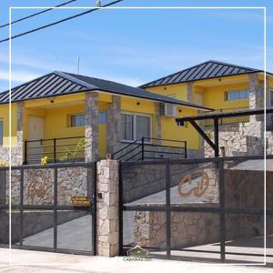 żółty dom z płotem przed nim w obiekcie Cabañas del Duende Potrero de los Funes w mieście Potrero de los Funes