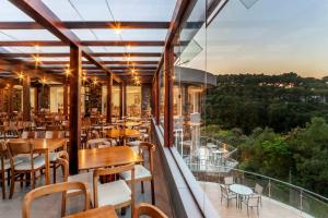 um restaurante com mesas e cadeiras numa varanda em Laghetto Resort Golden Oficial em Gramado