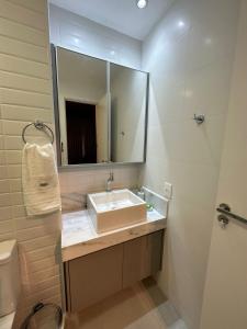 a bathroom with a sink and a mirror at Vida Urbana - Working - Setor Oeste in Goiânia