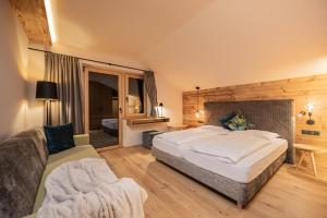 Cette chambre comprend un grand lit et un canapé. dans l'établissement myLoisl Apartments, à Lutago