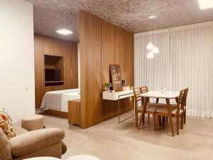 a bedroom with a bed and a table and chairs at Vida Urbana - Zen - Setor Oeste in Goiânia